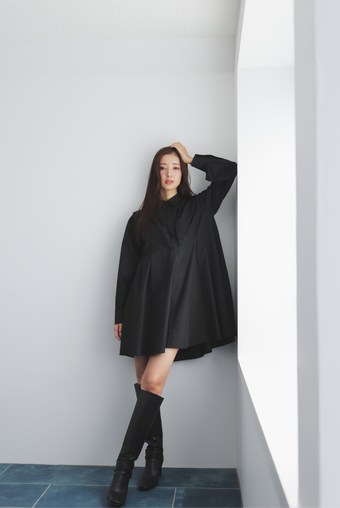 エンブロイダリーミニシャツワンピース・ロングブーツを着用した女性