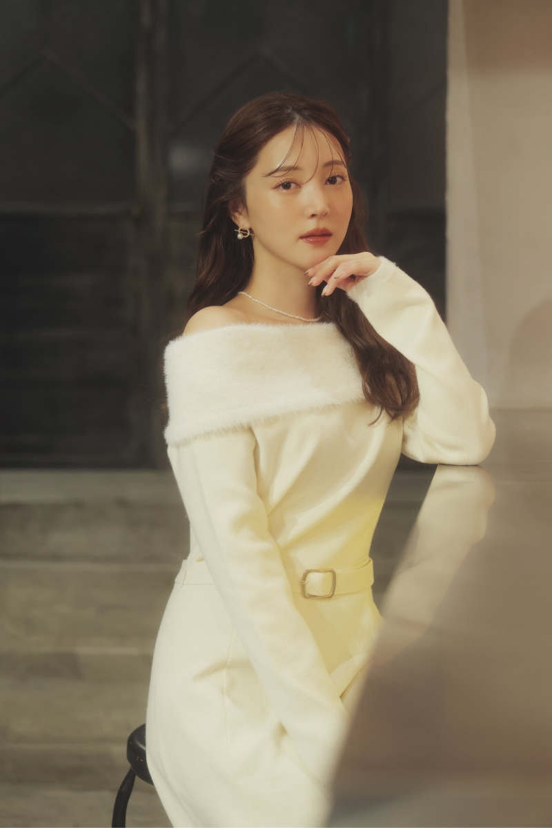 フェザートリム配色ドッキングワンピース・サークルモチーフピアスを着用した女性