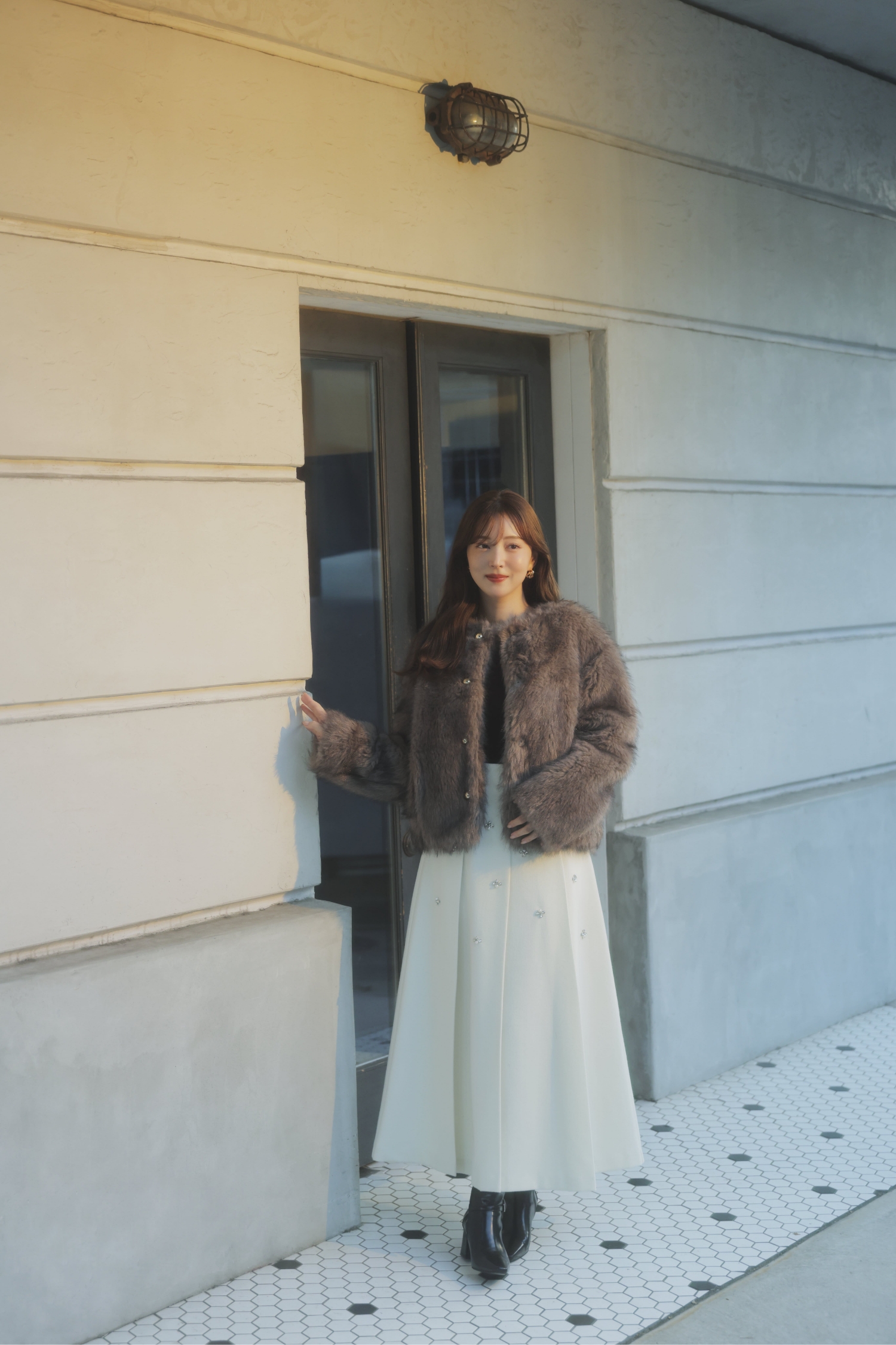 ゴールドボタンファージャケット・ベロアドレープトップス・ワイドタックビジュースカート・ベルトデザインショートブーツを着用した女性