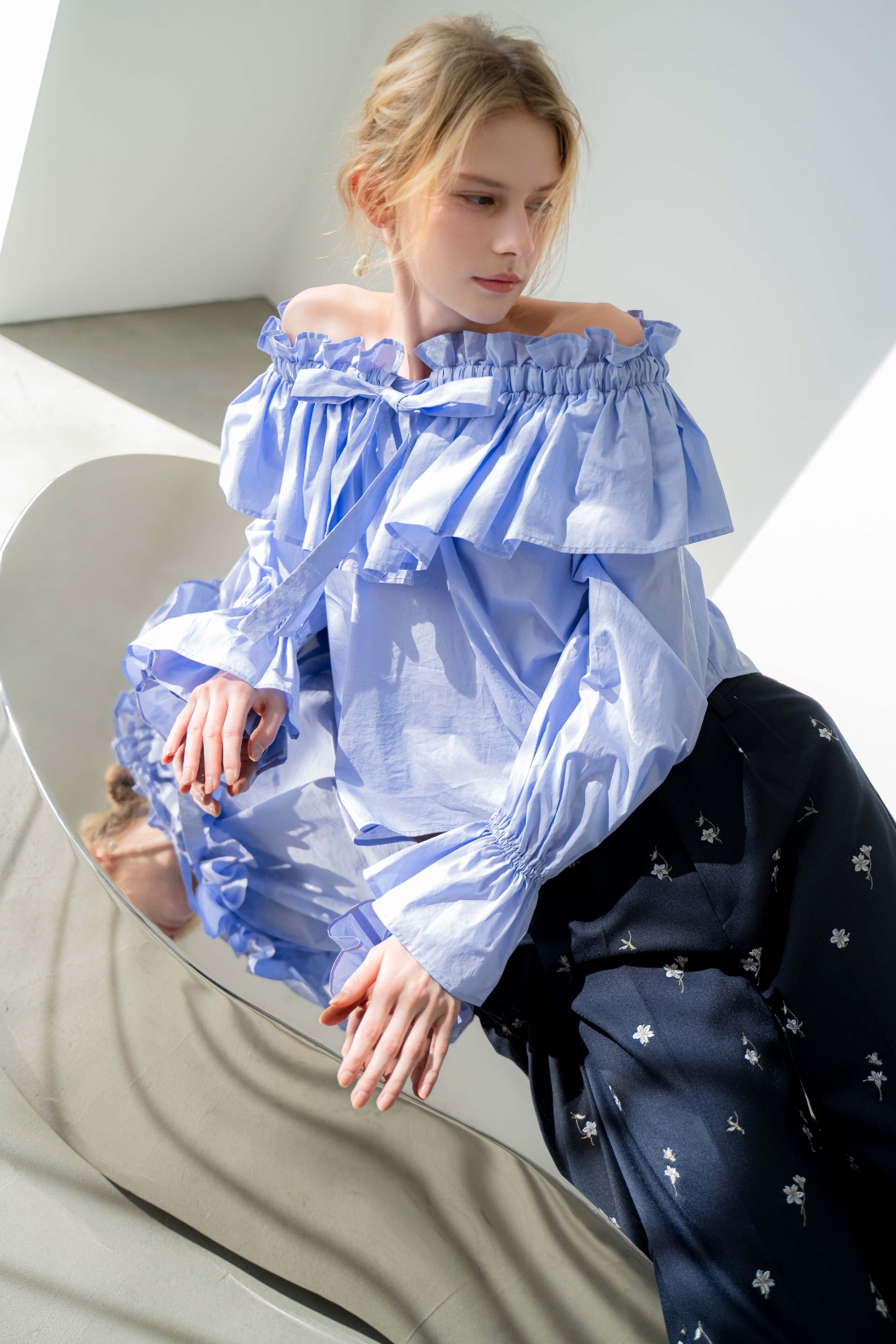 フレアカラータイブラウス・フラワー刺繍パンツ・バロックパールアシメピアスを着用した女性