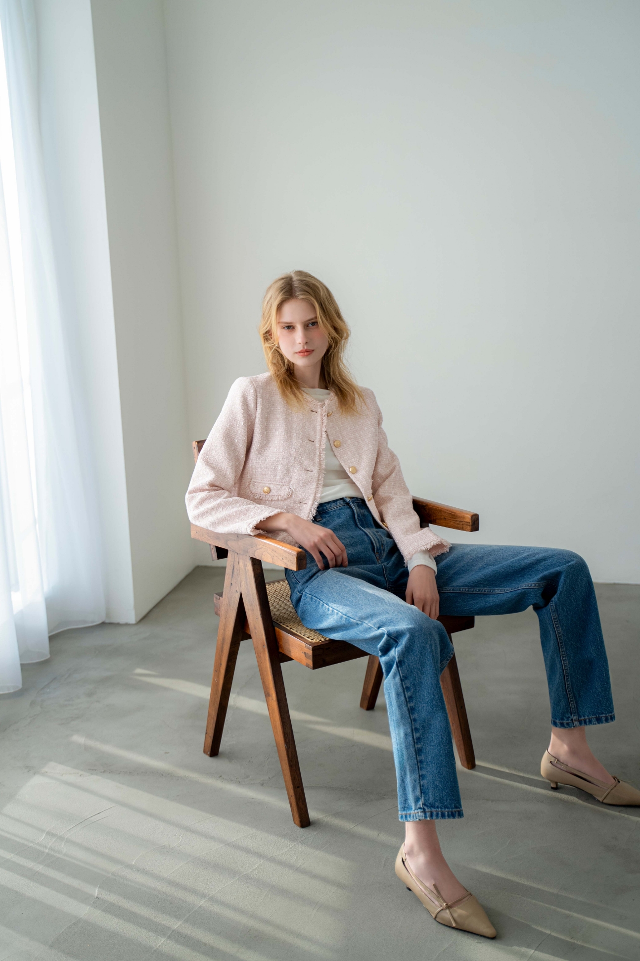 ツイードジャケット・シアードレープカットソー・ストレートデニムパンツ・サイドノットパンプス・スクエアビジューピアスを着用した女性