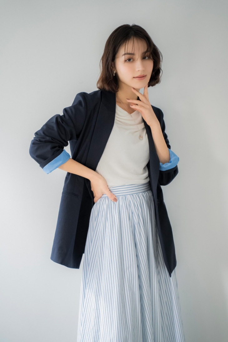 4Bダブルブレストジャケット・シアードレープカットソー・ストライプフレアスカート・スクエアビジューピアス・ニュアンスデザインネックレスを着用した女性の画像