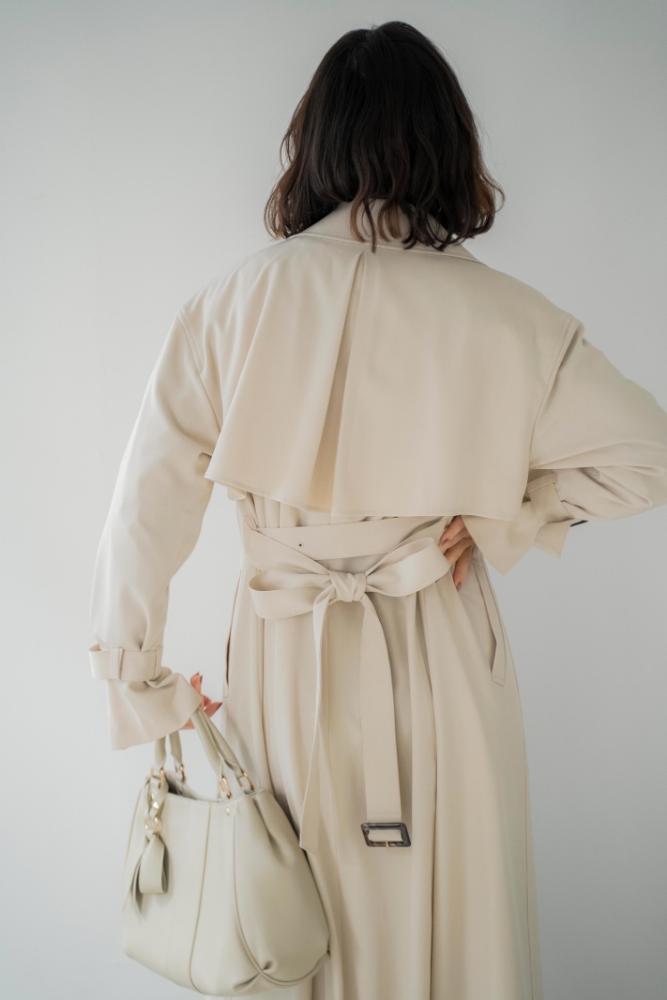 オーバートレンチコートを着用した女性の後ろ姿の画像