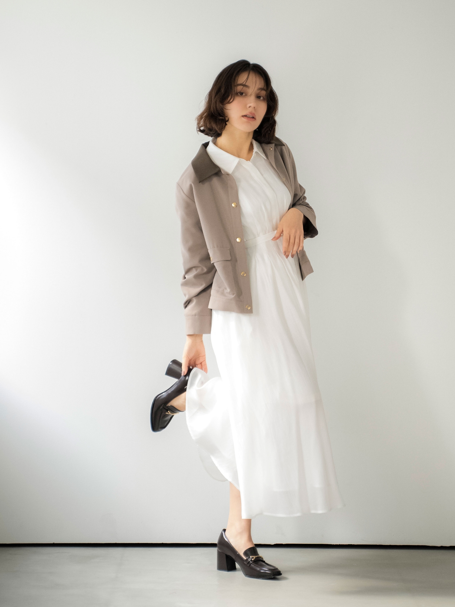 アウトポケットブルゾン・シアーシャツワンピース・スクエアビットローファーを着用した女性の画像