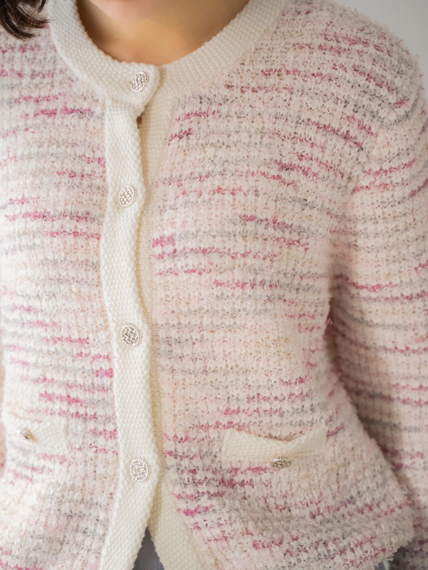 ツイードニットカーディガンを着用した女性のアップの画像