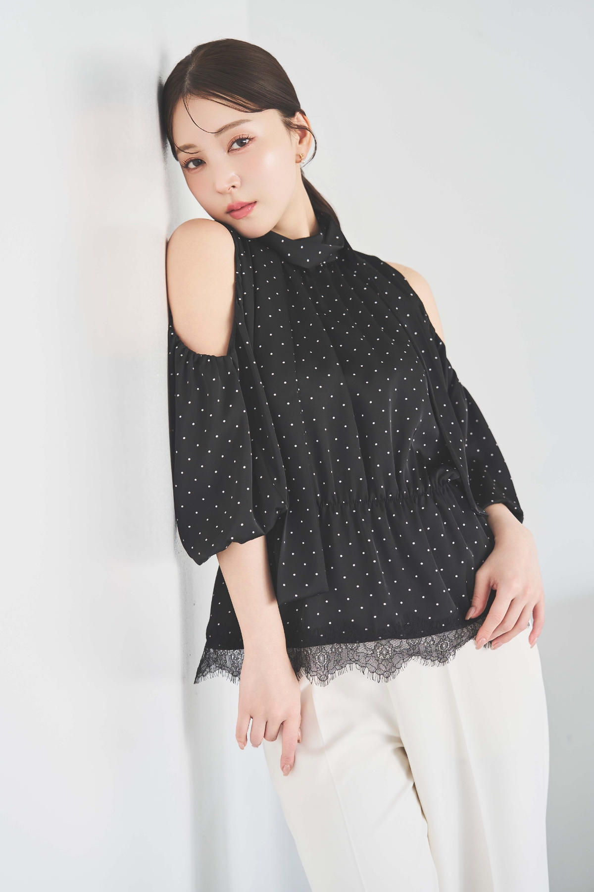 裾レースギャザーブラウス・ストレートパンツを着用した女性