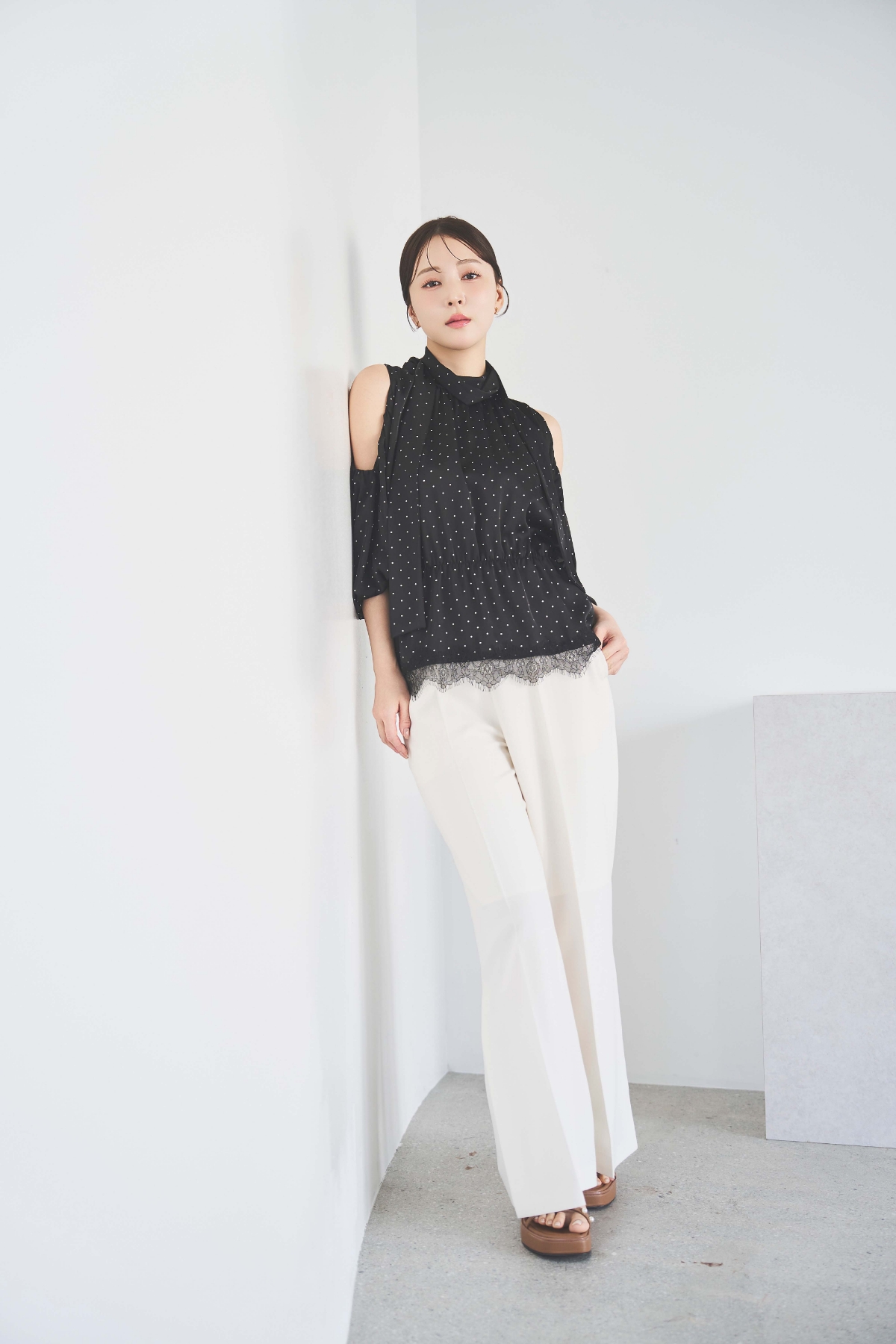 裾レースギャザーブラウス・ストレートパンツ・クロスパールプラットフォームサンダルを着用した女性