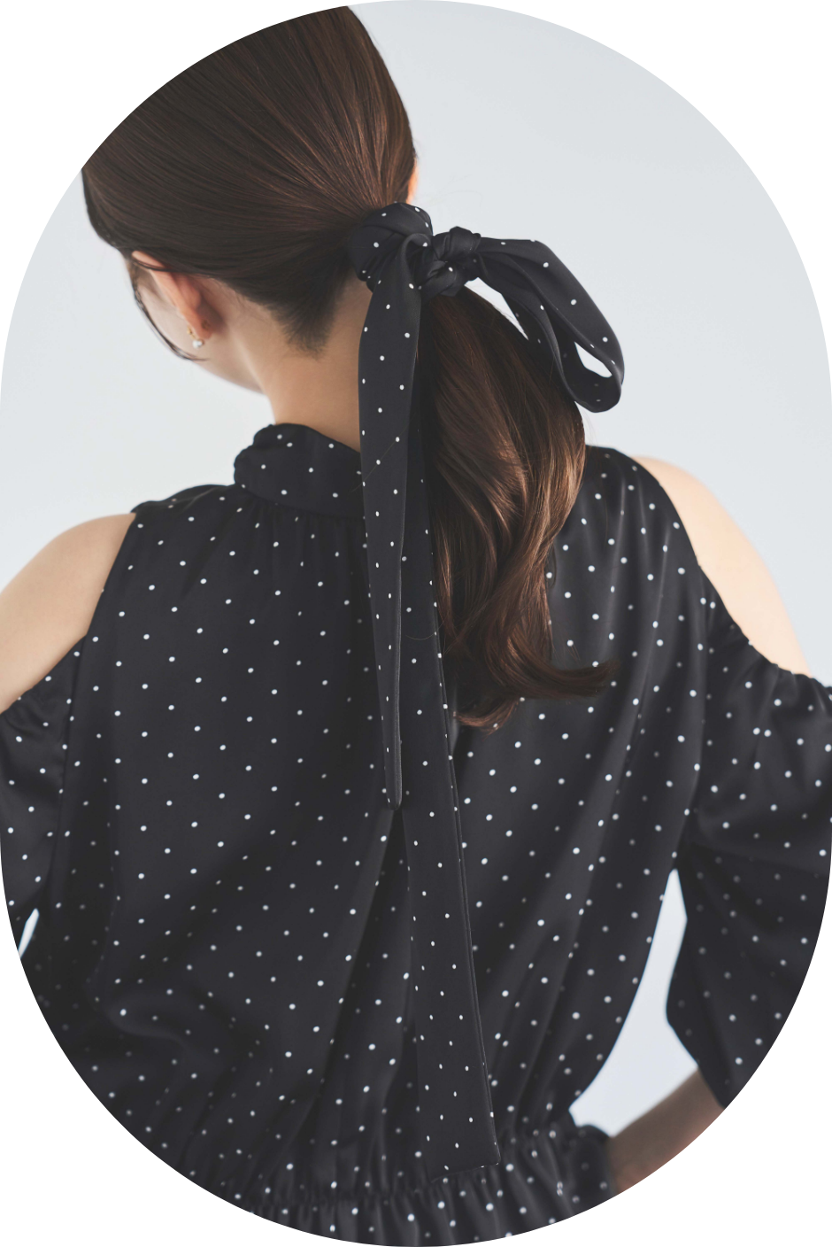 裾レースギャザーブラウスを着用した女性の後ろ姿