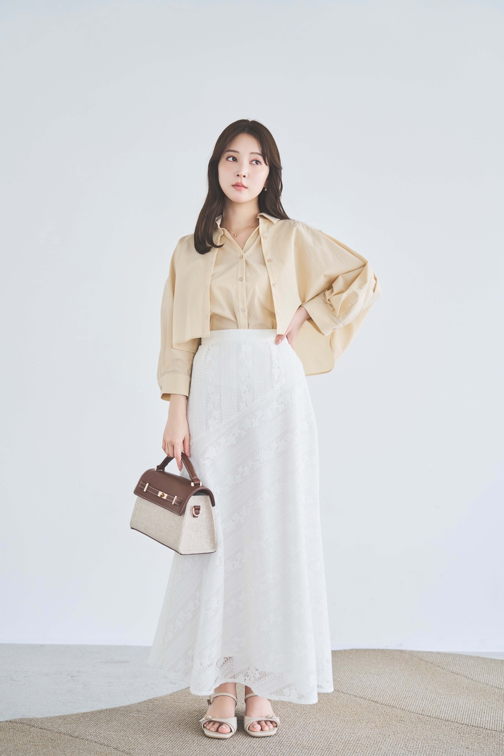 レイヤードライクシャツ・【SSサイズあり】パネルレーススカート・スクエアビジューピアスを着用した女性