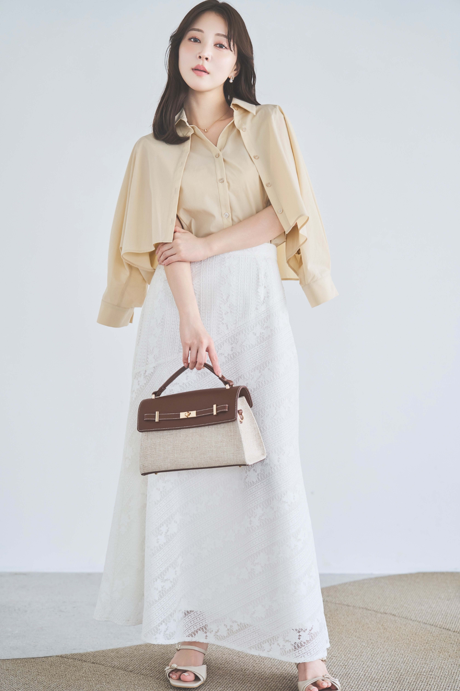 レイヤードライクシャツ・【SSサイズあり】パネルレーススカート・スクエアビジューピアスを着用した女性