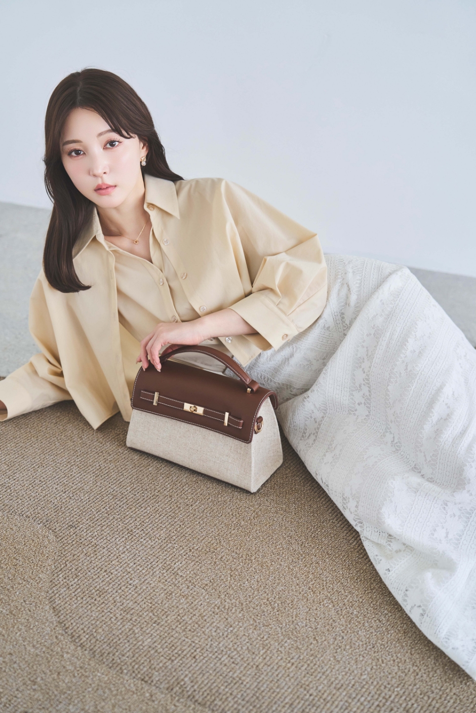 レイヤードライクシャツ・【SSサイズあり】パネルレーススカート・スクエアビジューピアスを着用した女性