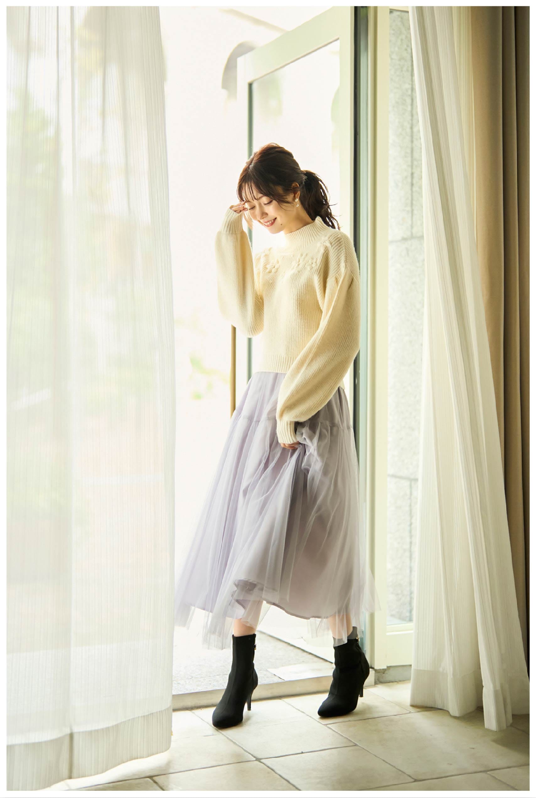 ボリュームスリーブニット,配色刺繍フラワースカート,バックビジューニットブーツ,ファーフラップバッグ,ハーフモチーフネックレスを着用している女性モデルの写真3