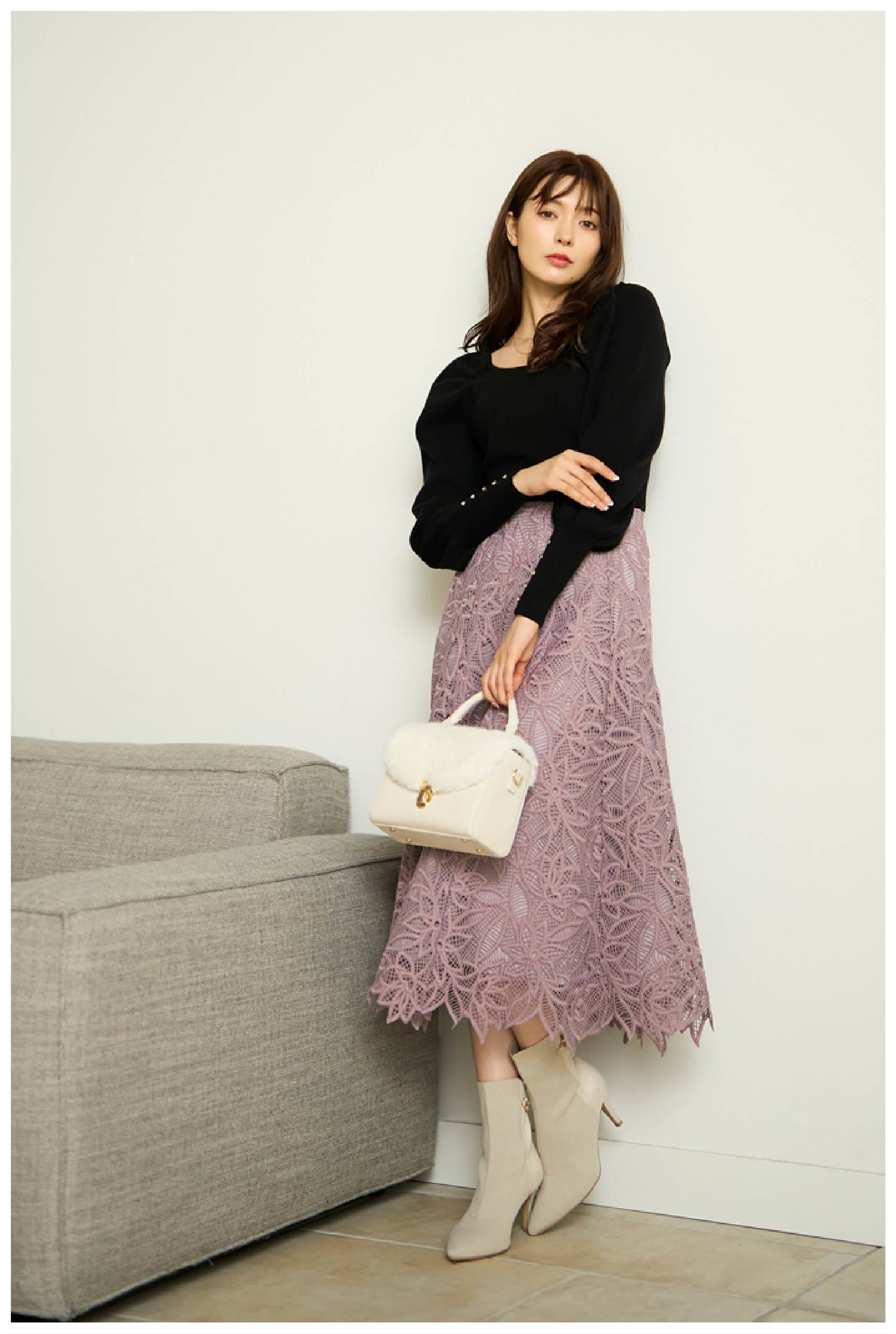 ボリュームスリーブニット,配色刺繍フラワースカート,バックビジューニットブーツ,ファーフラップバッグ,ハーフモチーフネックレスを着用している女性モデルの写真1
